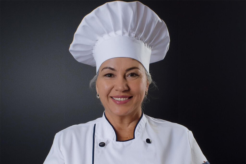 Chef H. Joulal, an experienced head chef specializing in Moroccan, Middle Eastern, and Italian cuisines, holding a dish she prepared